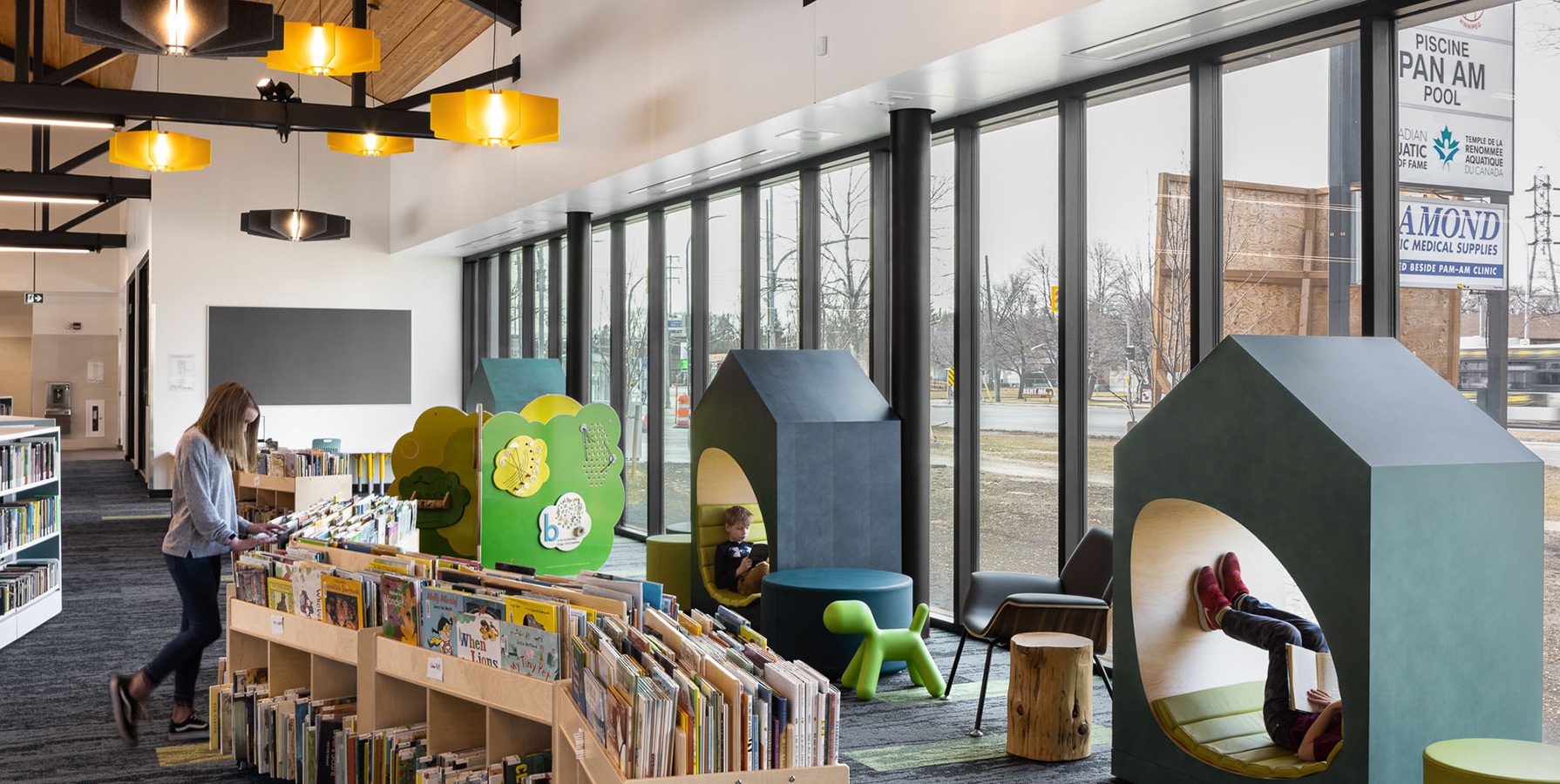 Children's Area with kids playing and reading inside Bill and Helen Norrie Library.