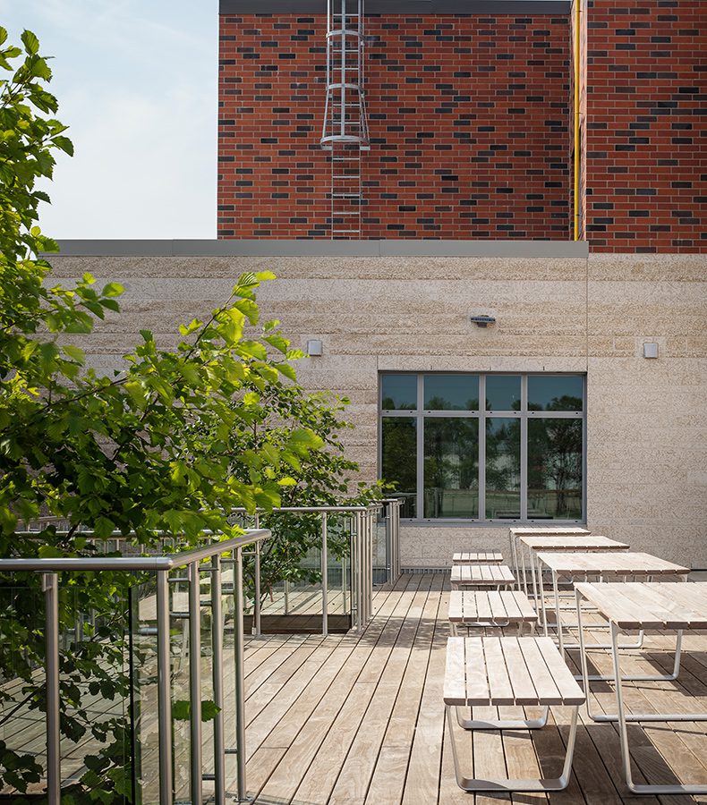 School exterior with picnic tables on large deck.