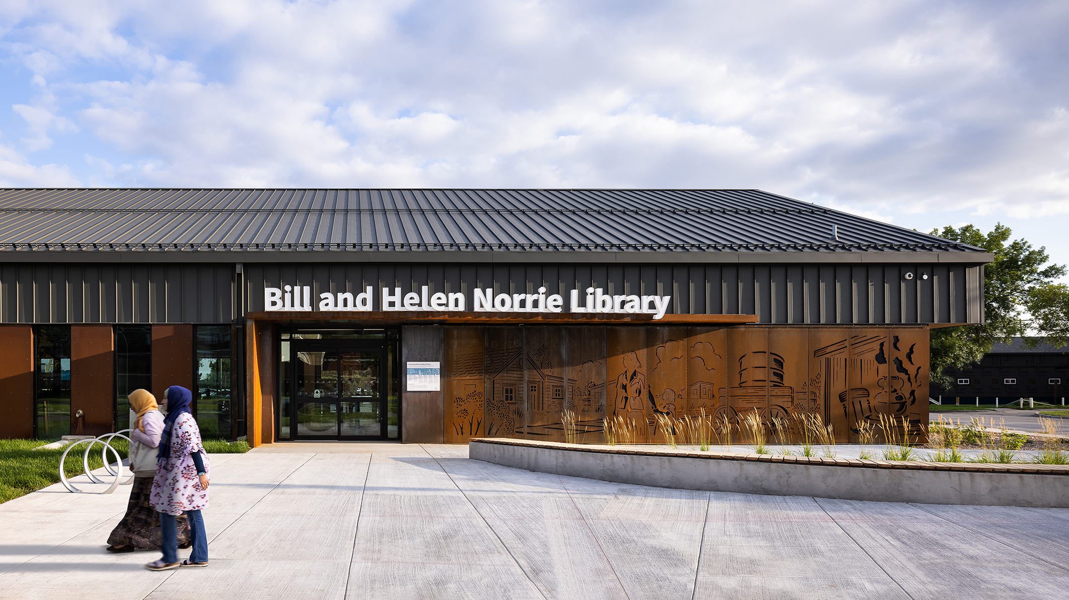 North entrance of Bill and Helen Norrie Library with community members in front.